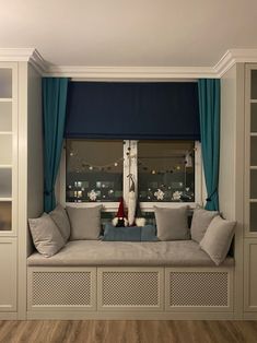 there is a window seat in the living room with blue drapes on the windowsill