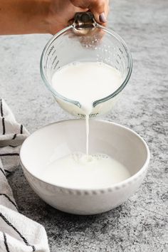 someone is pouring milk into a bowl