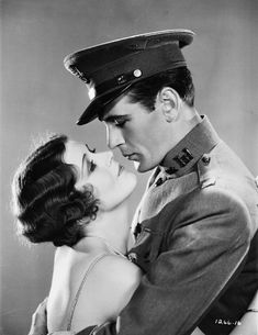 a man in uniform kissing a woman on the cheek