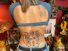 the back of a woman's body with tattoos on her lower and upper ribs