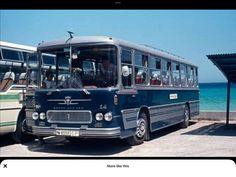 two buses parked next to each other near the ocean