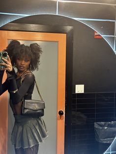 a woman taking a selfie in front of a mirror