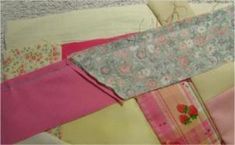 several pieces of fabric are stacked together on top of each other, including pinks and yellows