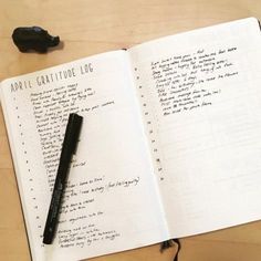 an open notebook with writing on it next to a pen