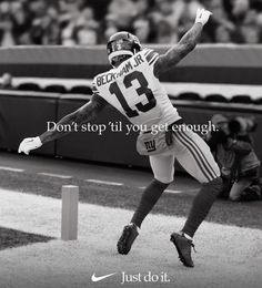 a black and white photo of a football player jumping in the air to catch a ball