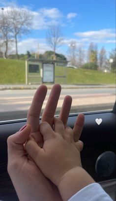 a person holding their hand up in front of a car window with the letter v on it