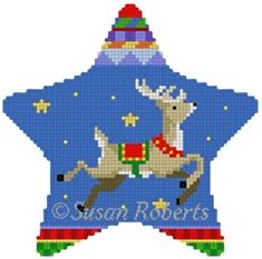 a cross stitch christmas ornament with a reindeer riding on it's back