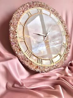 a clock that is sitting on a pink cloth