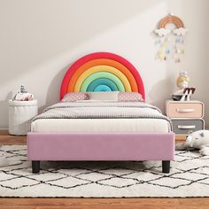 a bed with a rainbow colored headboard and foot board on top of the bed