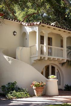 a large white house with two balconies next to it