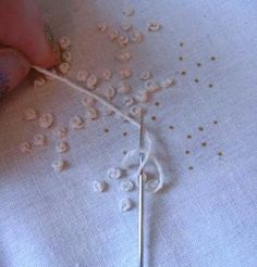 someone is stitching something with white thread