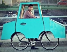 a man sitting in a small blue vehicle