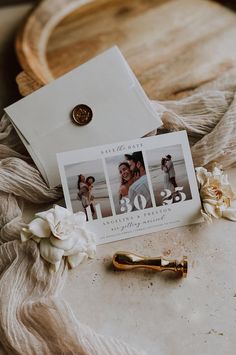 a couple's wedding photos are laying on top of a table next to a golden key