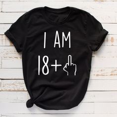 i am 50 plus t - shirt on white wood background with hand cursive