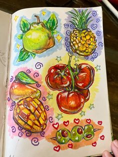 an open book with drawings of fruits and vegetables on the pages, including pineapples