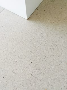 a white refrigerator freezer sitting inside of a kitchen next to a floor covered in dirt