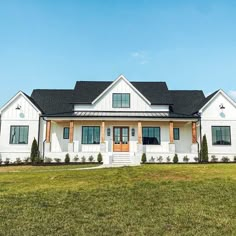 a white house sitting on top of a lush green field