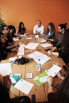 a group of people sitting around a wooden table