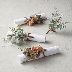 three napkins with flowers and greenery are laid out on the floor next to each other