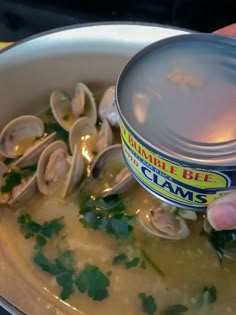 someone is dipping clams into a pot of soup