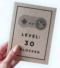 a hand holding a card with a game controller on it that says level 30 unlocked