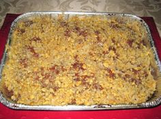 a casserole dish is sitting on a red place mat, ready to be eaten