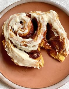 two cinnamon rolls sitting on top of a plate covered in icing and toppings