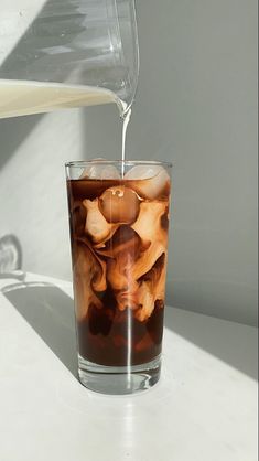 a glass filled with liquid sitting on top of a table