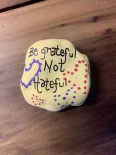 a painted rock that says be grateful not hateful