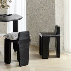 two black chairs sitting next to each other near a table