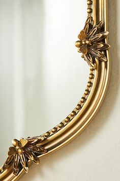 an ornate gold mirror hanging on the wall