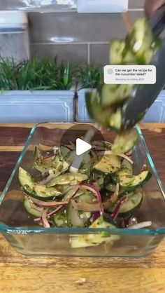 someone is cutting up some vegetables in a glass bowl with a knife on the table