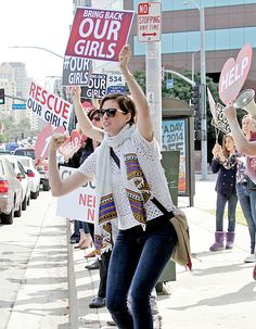 a group of women holding up signs on the street