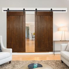 a living room with two white couches and wooden sliding doors