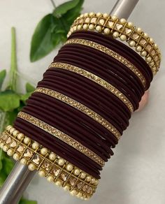 a close up of a bunch of bracelets on a table with flowers in the background