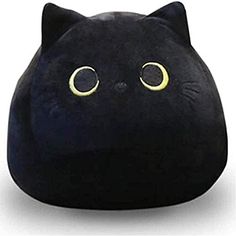 a black cat pillow with yellow eyes on it's head and ears, sitting in front of a white background