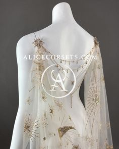 the back of a white dress with gold stars on it