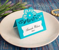 a plate with a place card on it next to some beads and flowers in the background