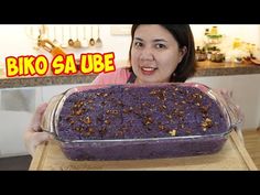 a woman is holding up a casserole dish in front of her face with the words biko sa ube on it