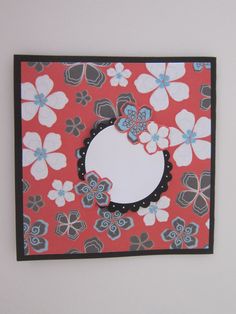 a card with flowers on it and a white circle in the middle is attached to a wall