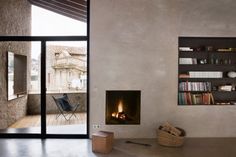 a living room with a fire place and bookshelves on the wall next to it