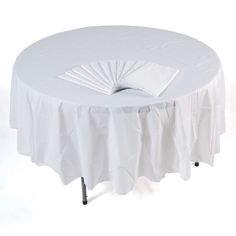 a white round table with pleated cloth on it and a napkin at the top