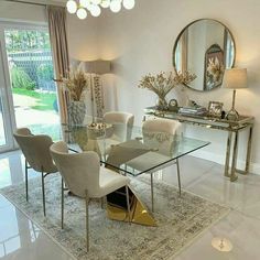 a dining room table with white chairs and gold accents