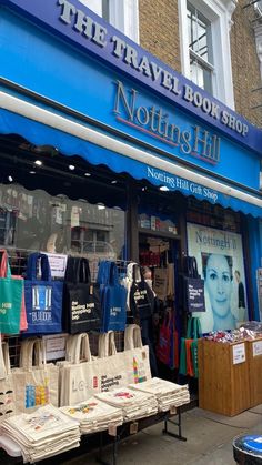 the travel book shop has many bags and totes on display in front of it