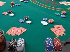 a casino table with chips and drinks on it