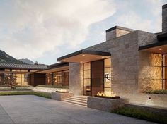 an exterior view of a modern house with stone walls and steps leading up to the front door