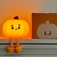 a little pumpkin sitting on top of a shelf next to a box