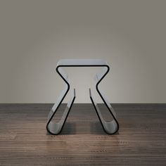 a white chair sitting on top of a wooden floor next to a table with a black frame