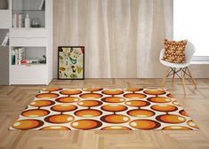 an orange and brown rug is on the floor in front of a white wall with a chair