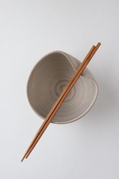 two chopsticks sticking out of a bowl